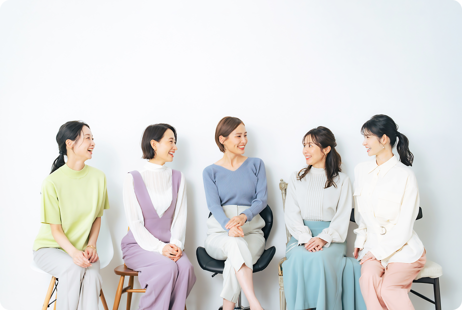 椅子に座り談笑する5人の女性の写真